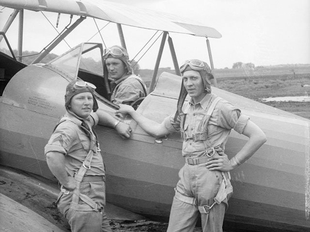 At Truax during World War II: a U.S. Army Air Corps trainee in the cockpit of a biplane, with two flight instructors outside.