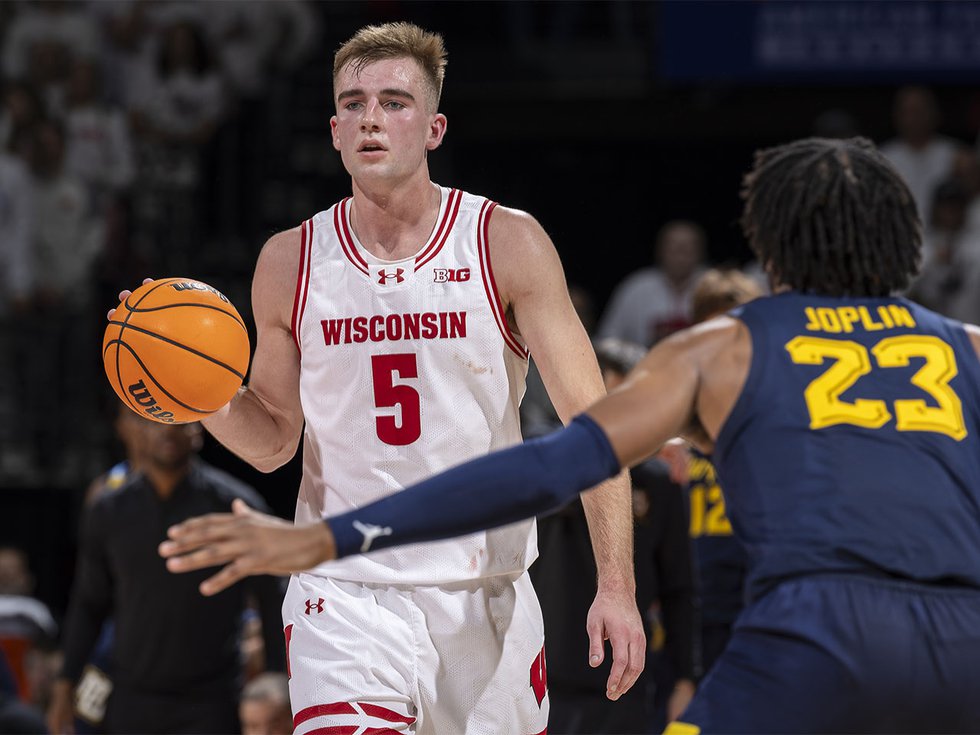 Tyler Wahl, wearing Badger 5 jersey, with a basketball on the court.