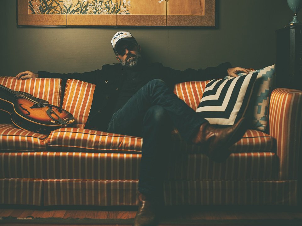 Jeffrey Foucault and a guitar on a couch.