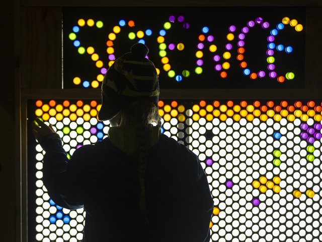 A person standing in front of a light display reading "science."