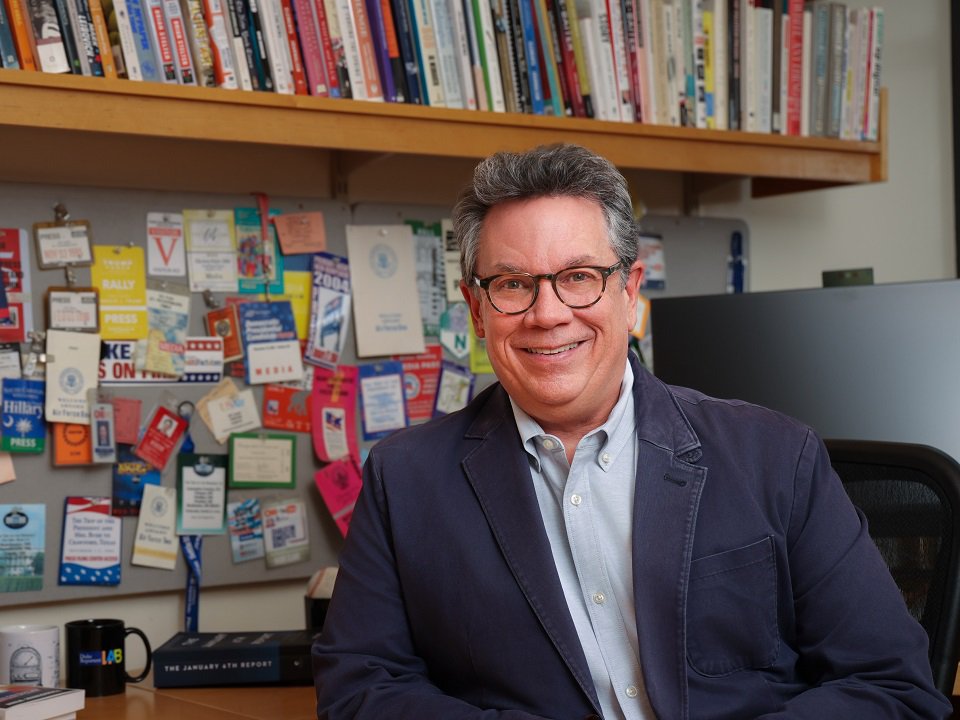 Bill Adair in front of a shelf of books.