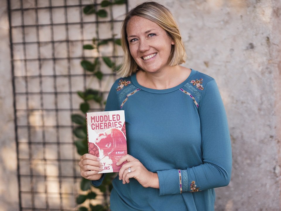 Sally Collins holding a copy of 'Muddled Cherries."