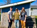 The three members of the band Whippets in front of a shed.