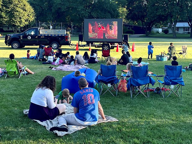 People in Meadowood park watching a movie.