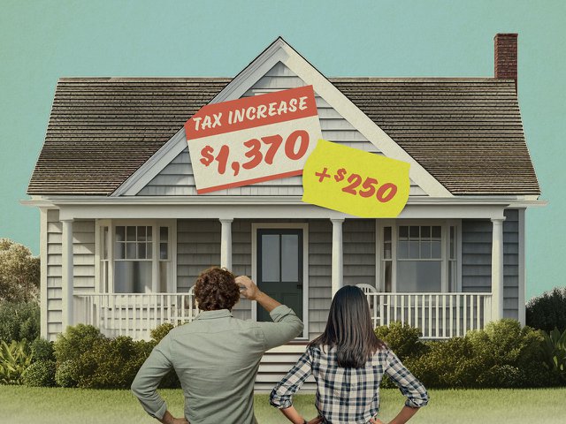 A couple looks at their house with increased tax price stickers on it.