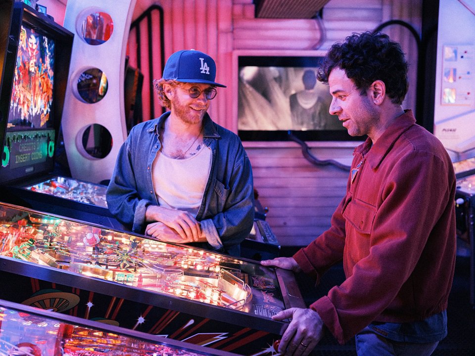 The two members of Dawes playing pinball.