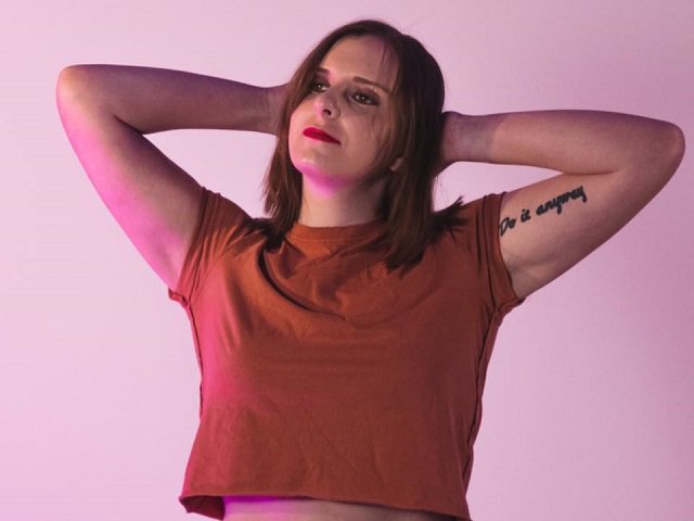 Mackenzie Moore in front of a lavender background.