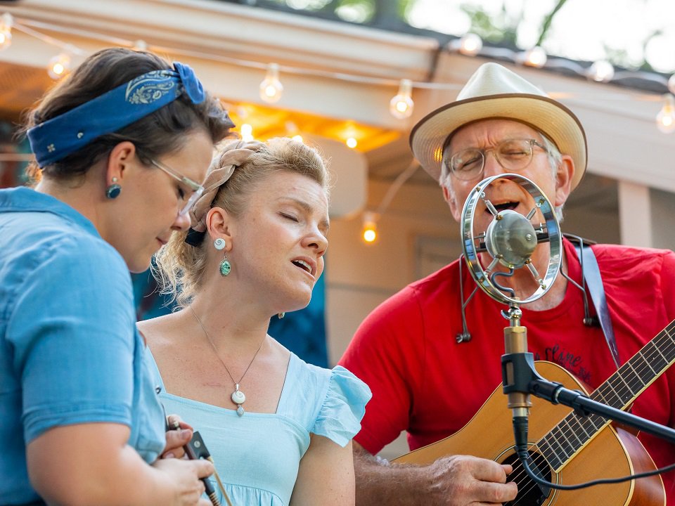 Krause Family Band gathered around a mic.