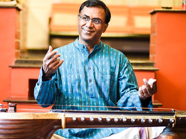 A person and an Indian musical instrument.