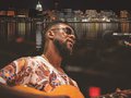 A collage of Adem Tesfaye playing guitar and a Madison skyline.