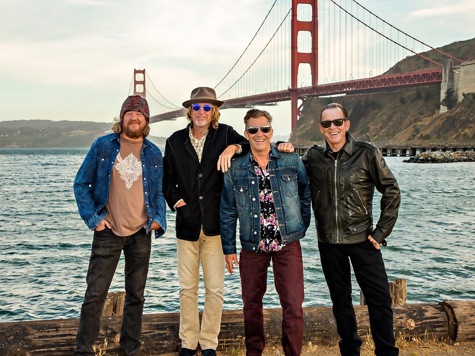 Tommy Castro and the Painkillers in front of a bridge.