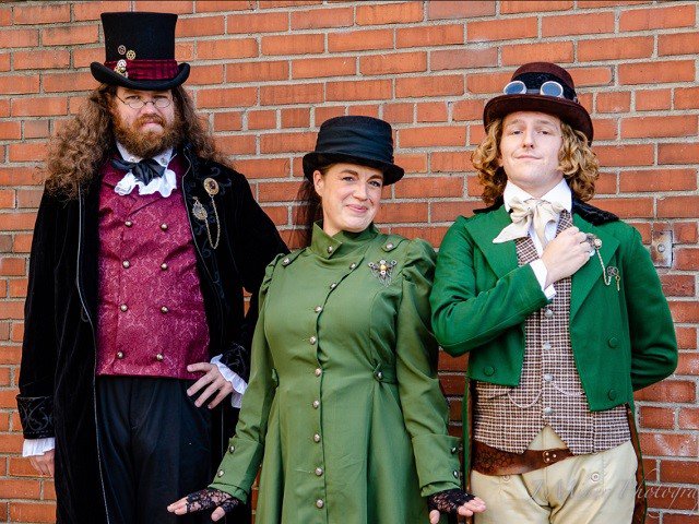 Cast members of "Ruddigore" in front of a brick wall.