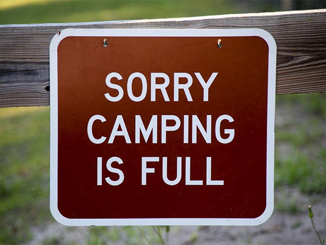 A sign indicating camping is full.
