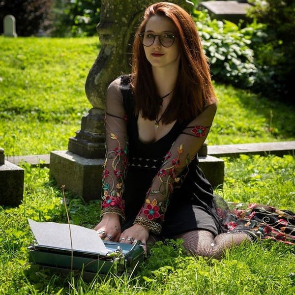 Writer Katya Zinn with typewriter in a cemetery.