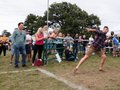 A man throwing a cow chip in front of onlookers.