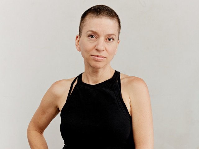 Ani DiFranco in front of a gray background.