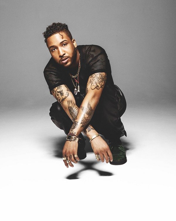 Ro James in front of a gray background