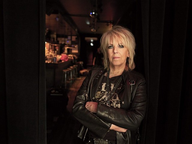 Lucinda Williams with her arms crossed.