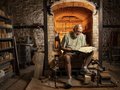 A man reads a sheaf of papers in front fo a brick structure.