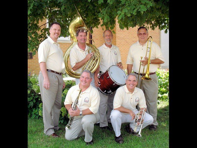 A six-piece band under a tree.