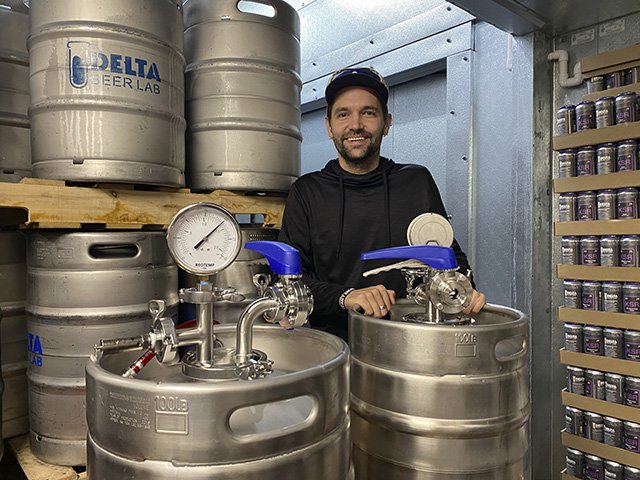 Brewer Piotrowski in front of brewing equipment.