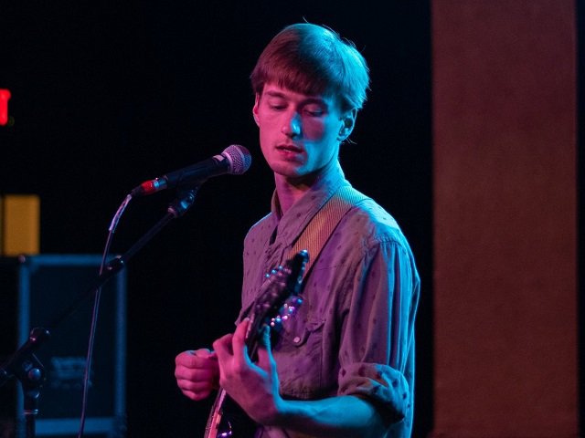 A person on stage with a guitar.