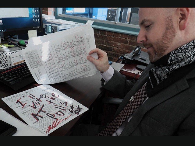 A man looks at a piece of hate mail.
