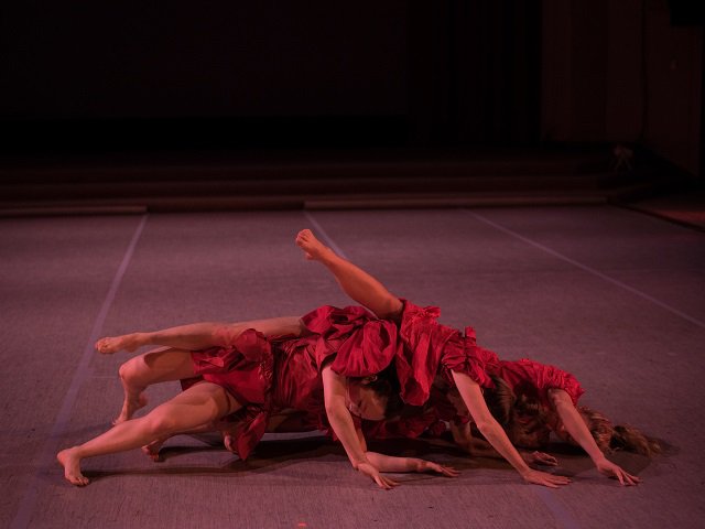Dancers in red dresses on stage.
