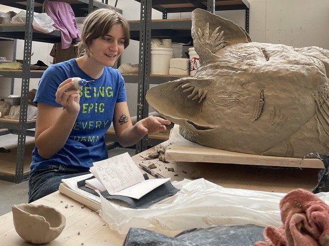 A person working on ceramics.