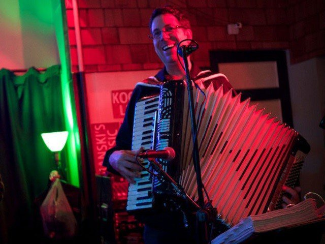 A person on stage with an accordion.