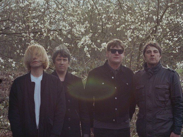 Four people in front of trees.