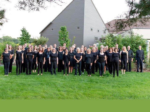 A group of people dressed in black on a lawn.