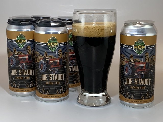 Cans and a pint glass of Joe Staudt beer.