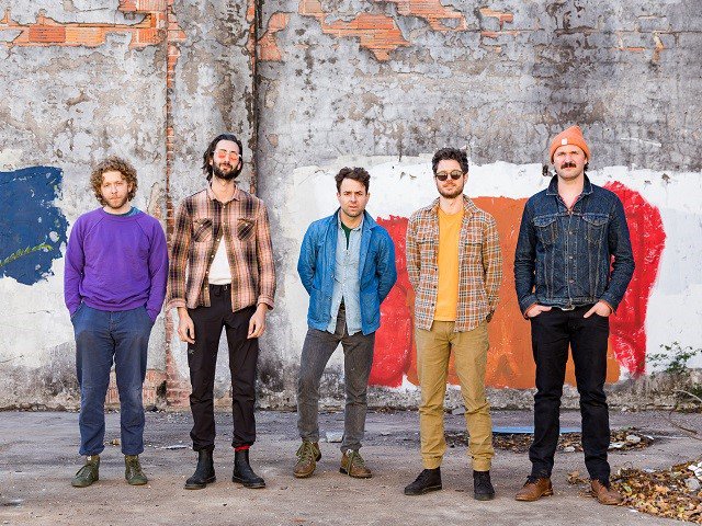 The band Dawes in front of a wall.
