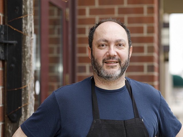 Francesco Mangano in a blue shirt and apron.