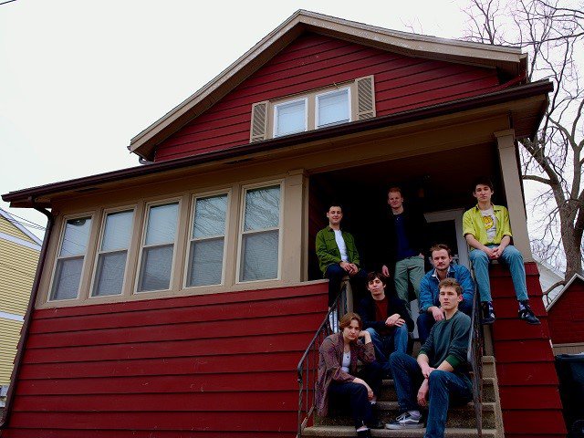The band East of Vilas in front of a house.