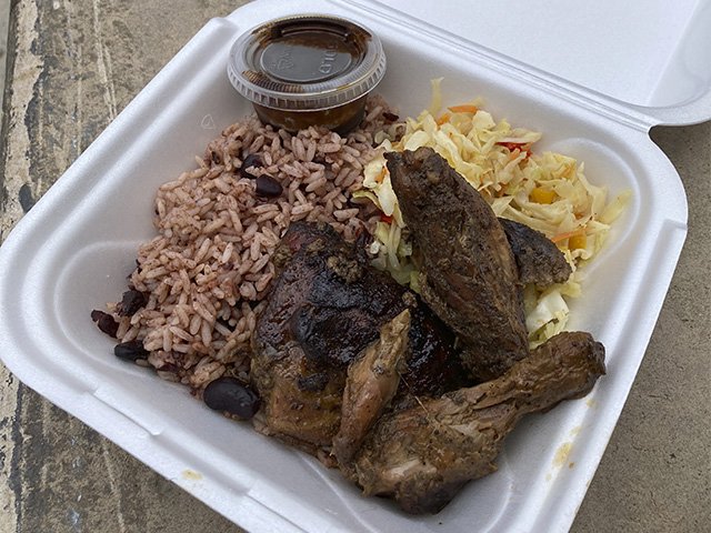 Jerk chicken in a takeout container.