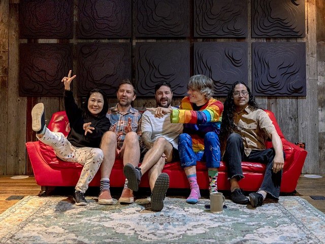 The five members of Deerhoof on a couch.