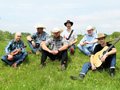 Six people sitting in a field.