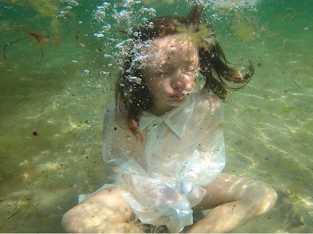 A child sitting underwater.