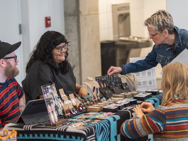 Artist Dakota Mace and customers at a Native Art Market event.