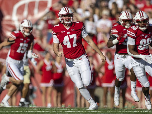 Badger football player wearing 47 jersey in action on field.