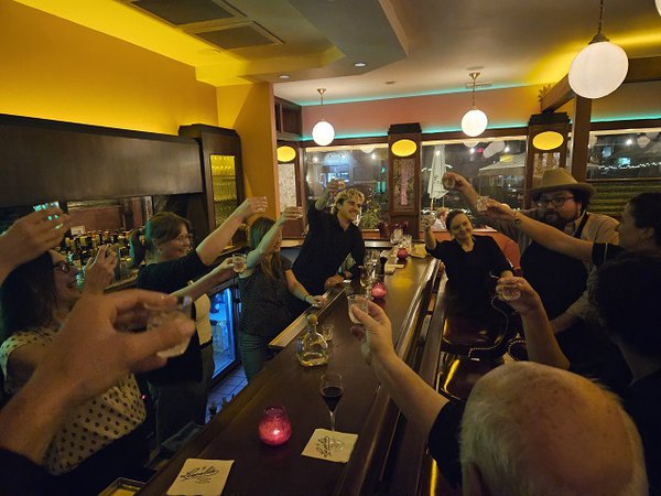 A group of people making a toast at the Fabiola's bar.