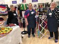 Three people at a craft fair vendor booth.