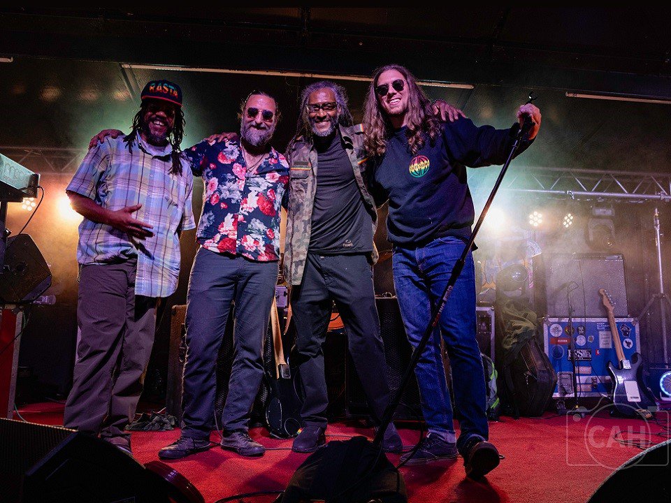 The band Natty Nation gathers for a picture on stage.