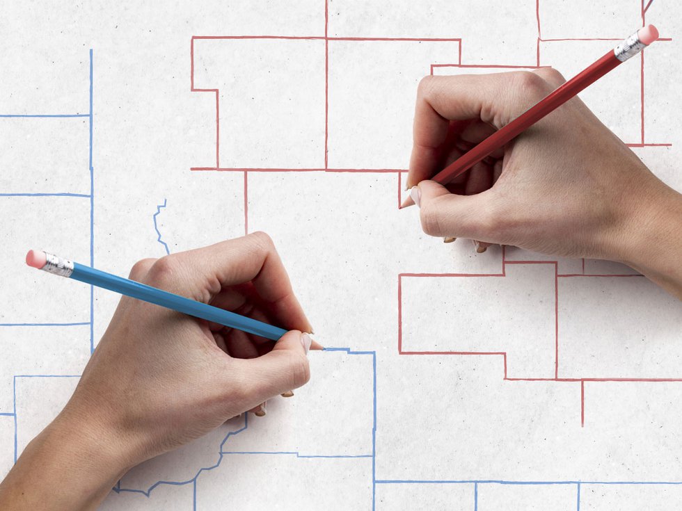 Hands drawing a Wisconsin district map using a red pencil and a blue pencil.