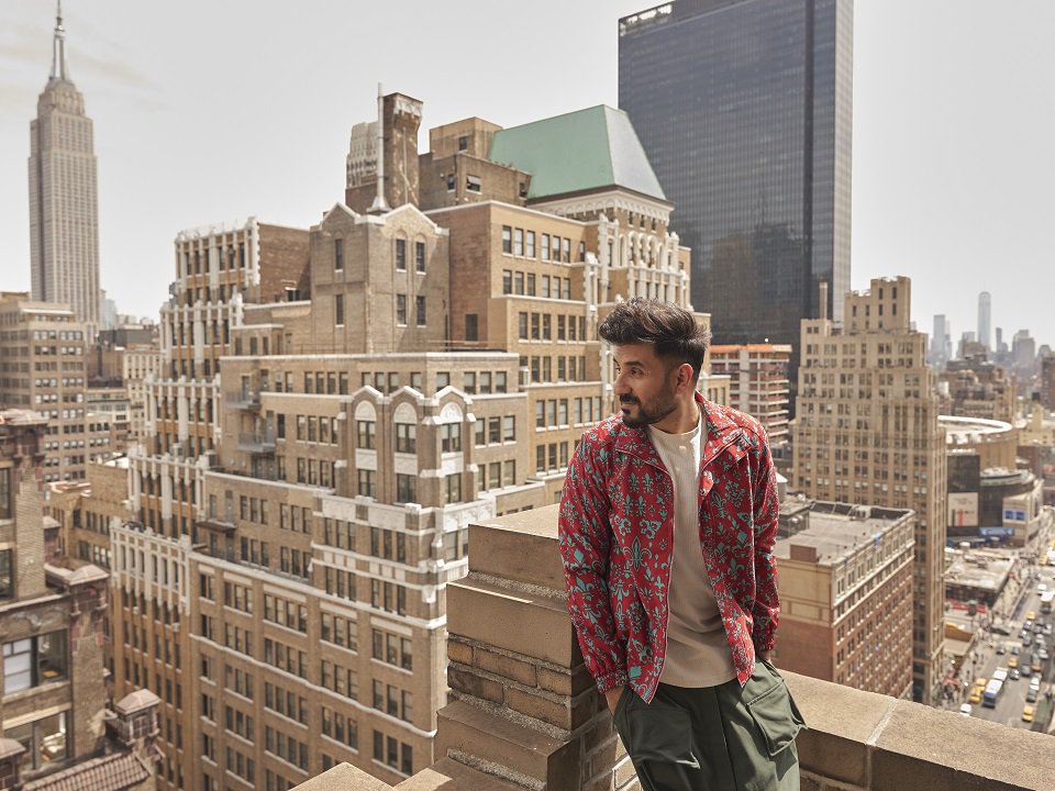 Vir Das on a rooftop in a big city.