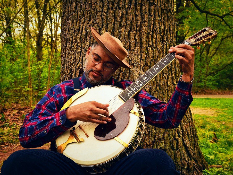 Dom Flemons and a large banjo.