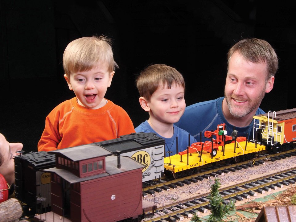 Kids and parents view a model train.