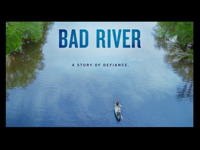 Title frame image from the film 'Bad River' with an aerial shot of two persons paddling a canoe.